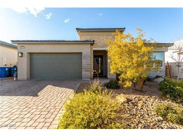 Single-story home with modern facade, two-car garage, and nicely landscaped front yard at 8941 Indigo Rose St, Las Vegas, NV 89166