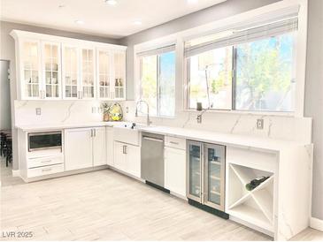 Spacious kitchen with white cabinets, quartz countertops, and stainless steel appliances at 9701 Ann Arbor Ln, Las Vegas, NV 89134