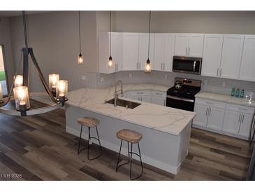 Modern kitchen with white cabinets, quartz countertops, and island at 1908 Quail Point Ct, Las Vegas, NV 89117