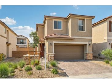 Two-story house with a brown brick facade, two-car garage, and landscaped front yard at 1937 Shanon Michelle Ave, North Las Vegas, NV 89031