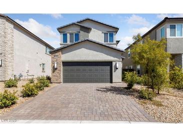 Two-story house with gray exterior, dark garage door, and landscaped front yard at 2720 High Echelon Rd, North Las Vegas, NV 89086