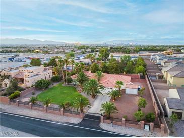 Aerial view of single-story house with large yard, palm trees, and distant mountain views at 274 Doobie Ave, Las Vegas, NV 89183