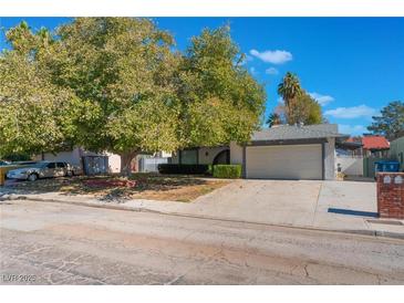 Single-story house with a large tree and driveway at 4850 Aveneda Grande, Las Vegas, NV 89121