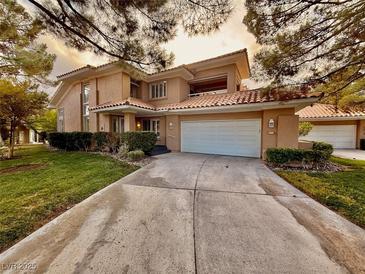 Two-story house with attached garage and landscaping at 4974 Crooked Stick Way, Las Vegas, NV 89113