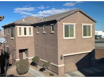 Tan two-story house with attached garage and landscaping at 658 Forest Peak St, Henderson, NV 89011