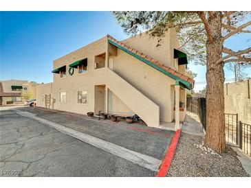 Tan stucco condo building with green accents and a staircase at 6750 Del Rey Ave # 262, Las Vegas, NV 89146