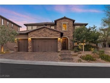 Two-story home with brick exterior, three-car garage, and landscaped yard at 11952 Girasole Ave, Las Vegas, NV 89138