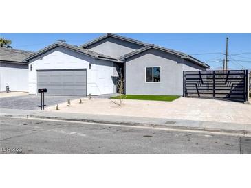 Charming single-story home with modern gray and white exterior, desert landscaping, and secure gated entry at 1308 E Nelson Ave, North Las Vegas, NV 89030