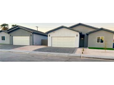 New construction home with modern gray and white exterior, two-car garage, and landscaped front yard at 1308 E Nelson Ave, North Las Vegas, NV 89030