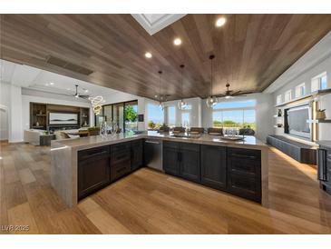 Modern kitchen features a large island, dark cabinetry, and wood ceiling at 2548 Faiss Dr, Las Vegas, NV 89134