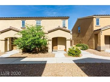 Tan two-story home with landscaped yard and walkway at 4598 Townwall St, Las Vegas, NV 89115