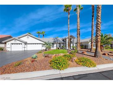 Single-story house with landscaped yard, driveway, and three-car garage at 4620 Clay Peak Dr, Las Vegas, NV 89129