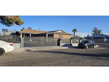 House exterior featuring a brick facade, gated entrance, and driveway at 5162 Woodruff Pl, Las Vegas, NV 89120