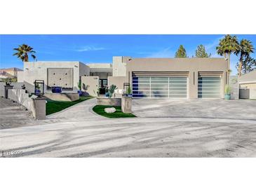 Modern home with a three-car garage and landscaped front yard at 8104 Via Del Cerro Ct, Las Vegas, NV 89117