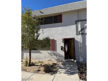 Two-story stucco building with a small front yard and walkway at 163 Greenbriar Townhouse Way, Las Vegas, NV 89121