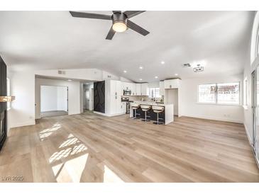 Open concept kitchen and living area with modern finishes and light wood flooring at 2276 Ray Kanel Dr, Las Vegas, NV 89156