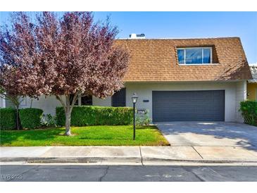 Updated single-story home with a gray garage door and well-manicured lawn at 3768 Territory St, Las Vegas, NV 89121