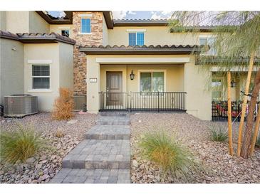 Two-story townhome with attractive stone accents and a welcoming front porch at 675 Omaggio Pl, Henderson, NV 89011