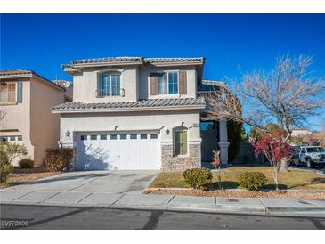 Two-story house with attached garage and landscaped front yard at 10332 Splendor Ridge Ave, Las Vegas, NV 89135