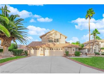 Two-story house with three-car garage, landscaped yard, and palm trees at 1968 Revere Ct, Henderson, NV 89014