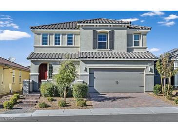 Two-story house with gray siding, red door, and a paved driveway at 3494 Brezine Ave, Henderson, NV 89044