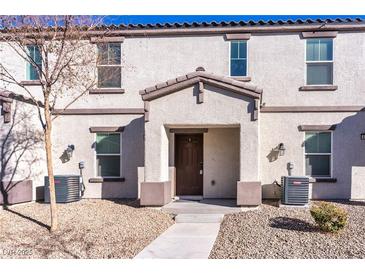 Tan two-story stucco home with brown accents, walkway, and landscaping at 4543 Pencester St, Las Vegas, NV 89115