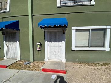 Green building exterior with blue awnings and a security door at 520 S 13Th St # D4, Las Vegas, NV 89101