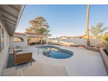 Inviting backyard oasis featuring a sparkling pool, patio furniture, and a covered seating area at 6750 Laronda Ln, Las Vegas, NV 89156