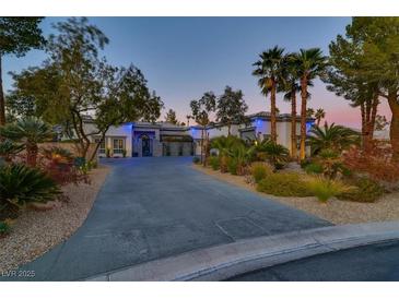 Luxury home with a large driveway, mature landscaping, and three-car garage at 7436 Oak Grove Ave, Las Vegas, NV 89117