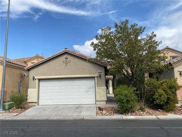 Tan two-story house with white garage door and landscaping at 8970 College Green St, Las Vegas, NV 89148