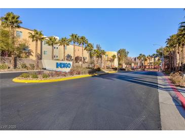 Indigo community entrance with palm trees and building view at 9378 Hilgard Ave, Las Vegas, NV 89178