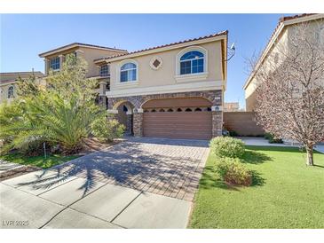 Two-story house with a brown garage door and landscaped front yard at 9635 Stoney Mesa Ct, Las Vegas, NV 89139