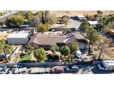 Aerial view of a single-story house with a large yard and surrounding buildings at 5785 W Russell Rd, Las Vegas, NV 89118