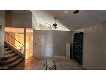 Living room with high ceilings, staircase, and a glass coffee table at 744 Willow Ave, Henderson, NV 89002