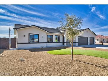 Charming single-story home with a three-car garage, desert landscaping, and an inviting facade at 1131 Blackhorn St, Pahrump, NV 89048