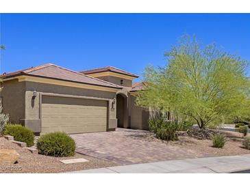 Single-story home with tan exterior, landscaped yard, and a two-car garage at 1359 Skylight Way, Mesquite, NV 89034
