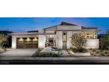 Modern home with light stone exterior, three-car garage, and landscaped front yard at 149 Tre Pietre St, Henderson, NV 89011