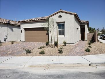 Single-story home with a two-car garage and landscaped front yard at 1706 Pondering Ave, North Las Vegas, NV 89031