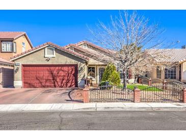 Single-story house with red garage door and landscaped yard at 1806 Hollyberry Ct, Las Vegas, NV 89142