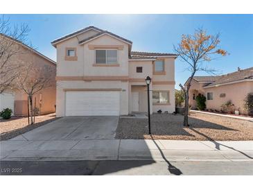 Two-story home featuring a two-car garage and low maintenance gravel landscaping at 4929 Morning Falls Ave, Las Vegas, NV 89131