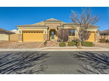 Single-story home with a stone and stucco exterior, two-car garage, and landscaped front yard at 7260 Fruitful Harvest Ave, Las Vegas, NV 89131