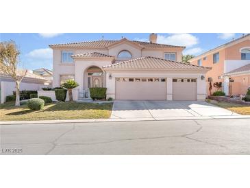 Two-story house with a three-car garage and manicured lawn at 31 Castle Creek Ct, Las Vegas, NV 89148