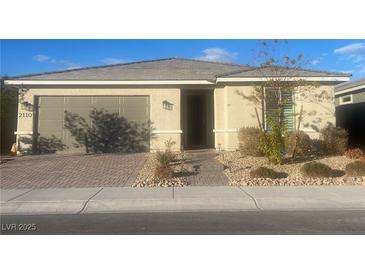 Single-story home with a two-car garage and landscaped front yard at 2110 Millergrove Ave, North Las Vegas, NV 89086