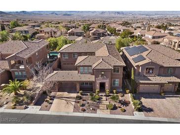 A beautiful aerial view of the community and home with mature landscaping and a tile roof at 2717 Mona Lisa St, Henderson, NV 89044