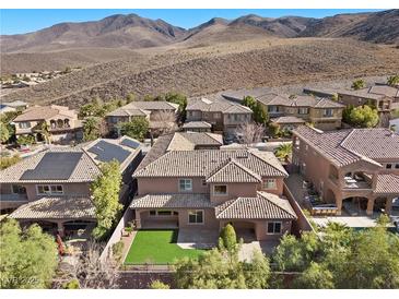 Sprawling home featuring a vibrant lawn and stylish tile roofing, set against a picturesque mountain backdrop at 2717 Mona Lisa St, Henderson, NV 89044