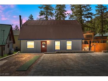 Gray metal exterior home with brown roof, and a paved driveway at 4765 Silver Tip Trl, Mount Charleston, NV 89124