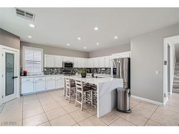 Spacious kitchen featuring white cabinets, an island, and stainless steel appliances at 5599 Valley Mill St, Las Vegas, NV 89148