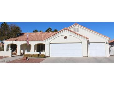 Single-story house with a three-car garage,desert landscaping, and Spanish-style tile roof at 7712 Wedlock Ln, Las Vegas, NV 89129