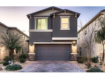 Two-story home with gray exterior, two-car garage, and landscaped front yard at 9181 Theodore Ct, Las Vegas, NV 89178