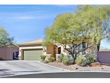 Single-story house with green garage door and landscaped yard at 10330 Glacier Mist Ave, Las Vegas, NV 89149